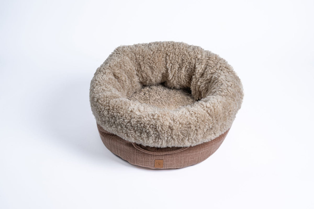Bovenaanzicht van de ronde Blush hondenmand met crème faux fur rand en oudroze linnenlook buitenzijde op witte achtergrond